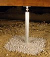 an installed galvanized steel support post in a crawl space